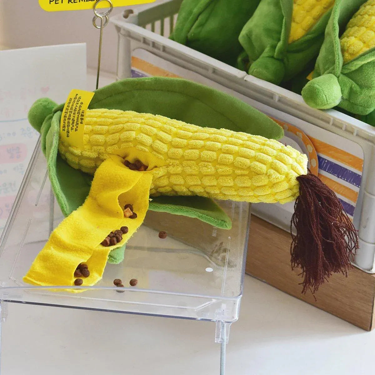 Corn Chew Toy with its tassel and fabric treat strip on a clear tray